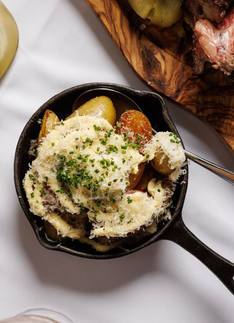 French-Brasserie-Dublin-Chef-Side-Dish Creamy side dish served in a skillet, topped with herbs and cheese at a French brasserie in Dublin