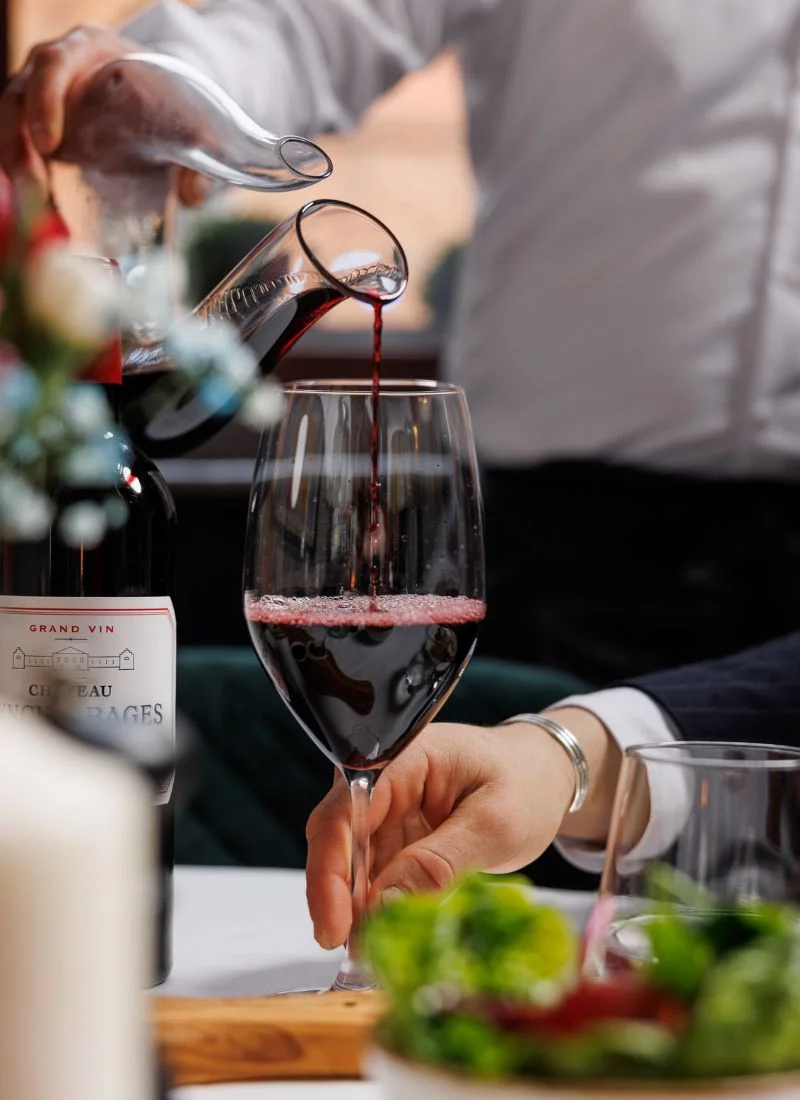 Red wine being poured into a glass during a fine dining experience at La Maison French restaurant in Dublin.