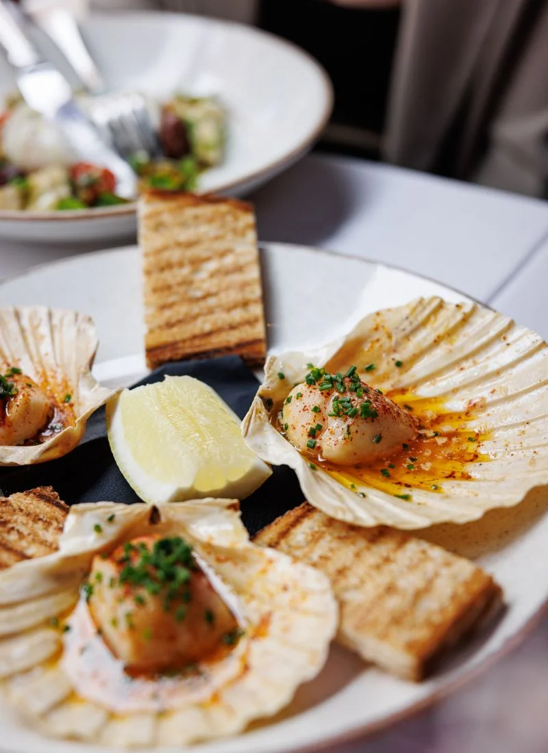 fine-dining-restaurant-dublin-seafood-starter Close-up of an elegant seafood starter served in shell plates with toast and lemon, presented at La Maison Dublin